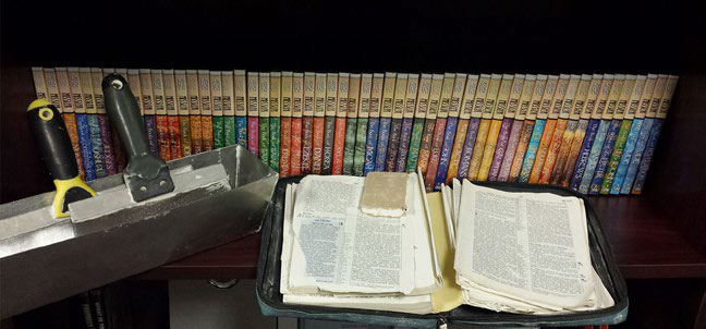 Commentaries, drywall tools, and drywall covered Bible.